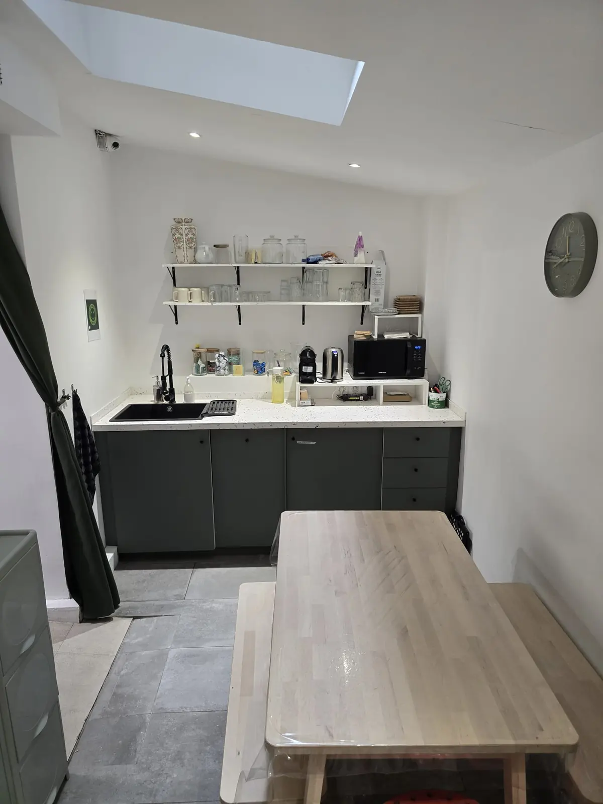Salle de repos avec coin cuisine et grande table en bois